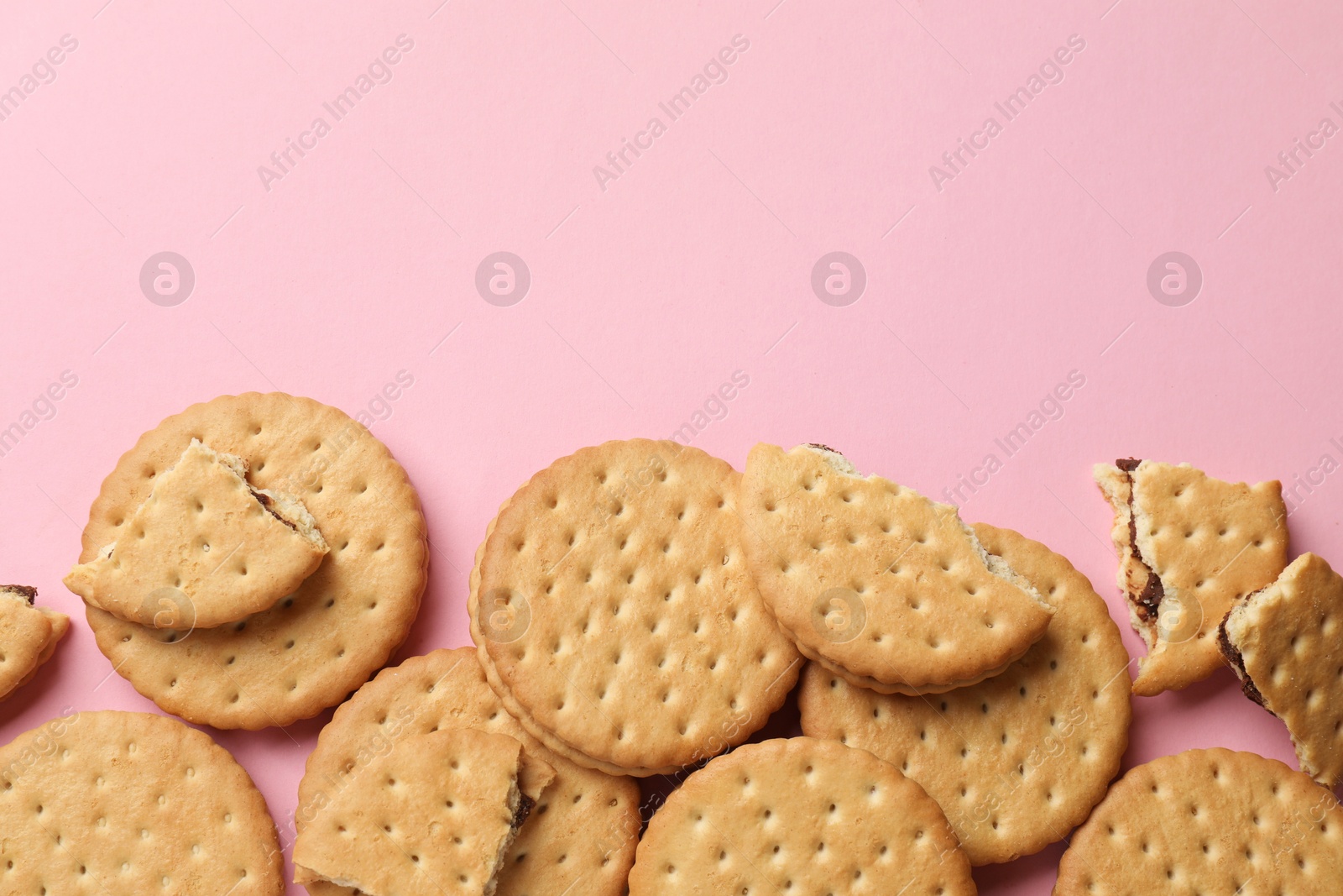 Photo of Tasty sandwich cookies on pink background, top view. Space for text