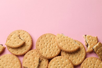 Tasty sandwich cookies on pink background, top view. Space for text