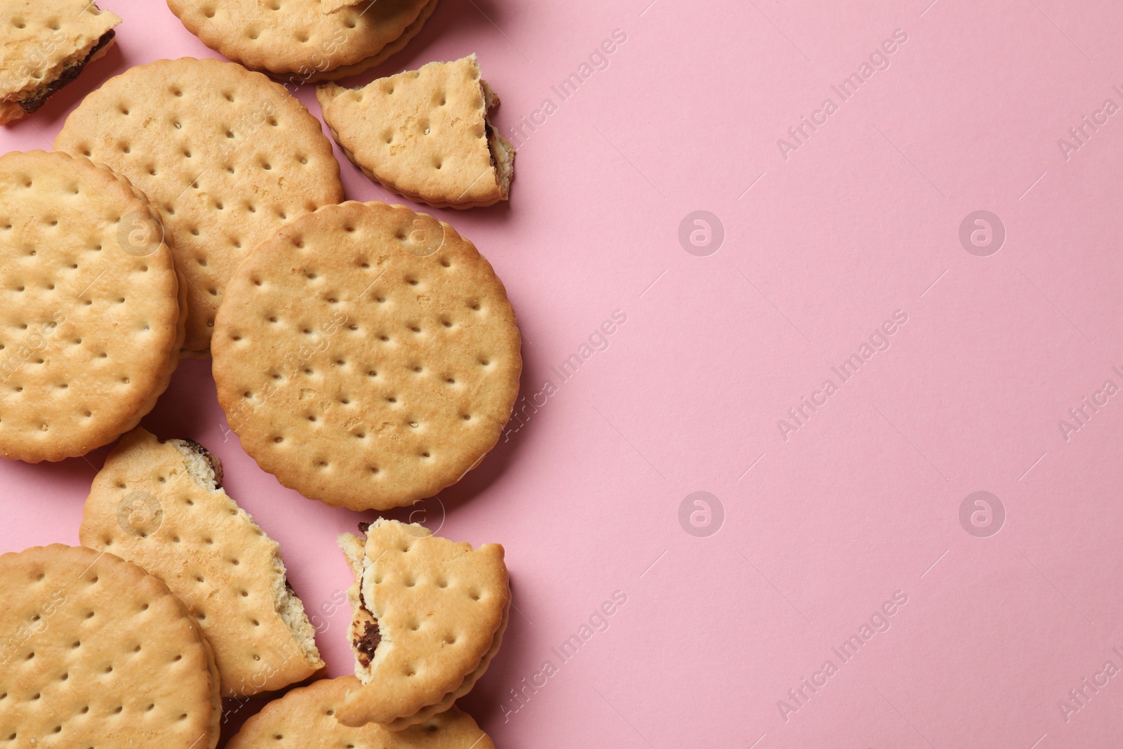 Photo of Tasty sandwich cookies on pink background, top view. Space for text