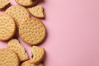 Tasty sandwich cookies on pink background, top view. Space for text