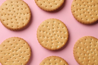 Photo of Tasty sandwich cookies on pink background, top view