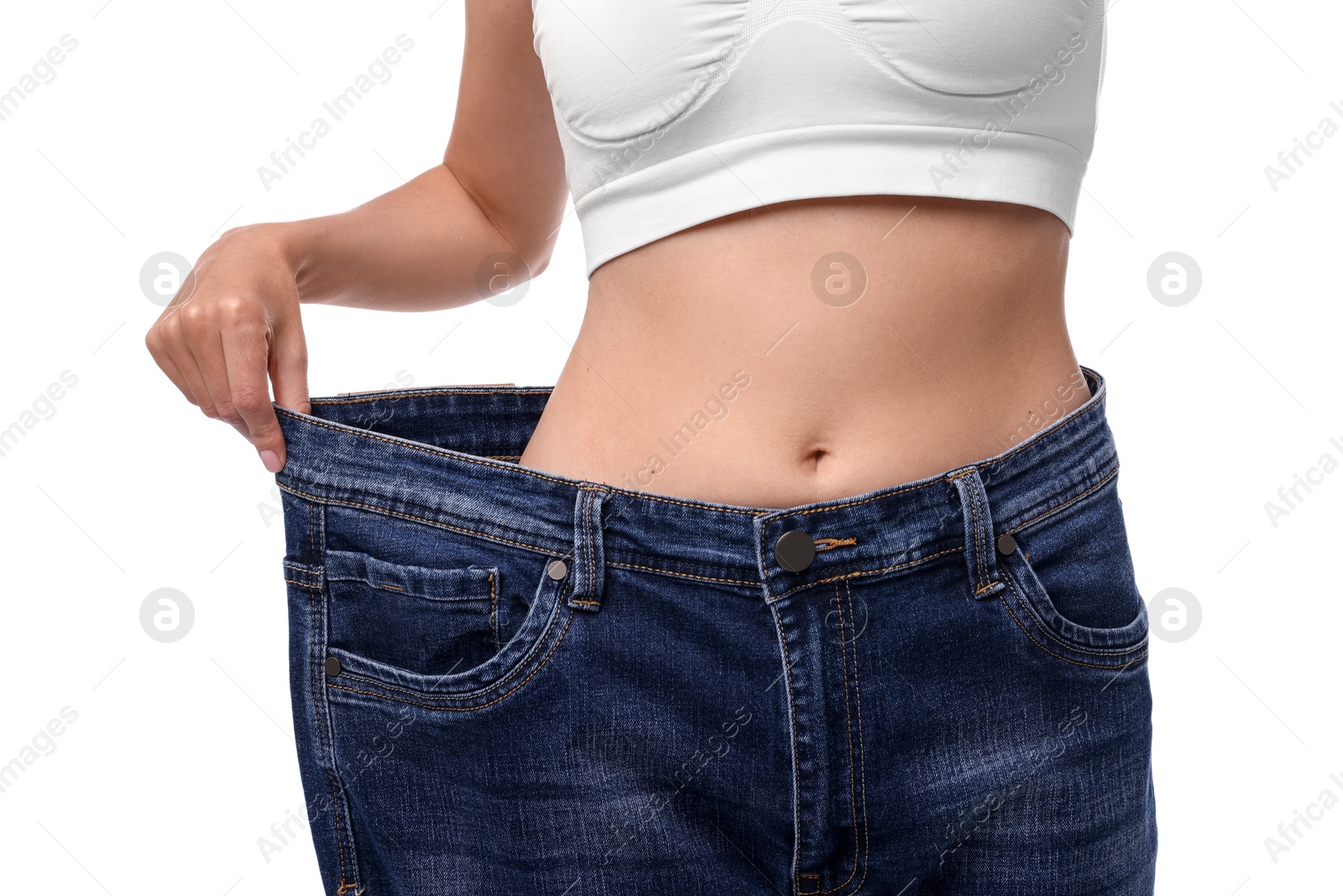 Photo of Diet and weight loss concept. Woman in big jeans showing her slim body on white background, closeup