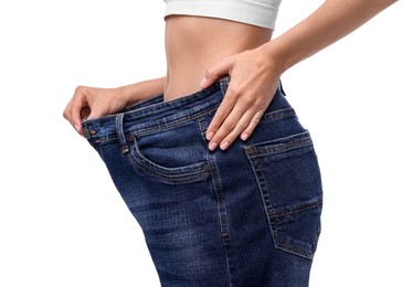 Photo of Diet and weight loss concept. Woman in big jeans showing her slim body on white background, closeup