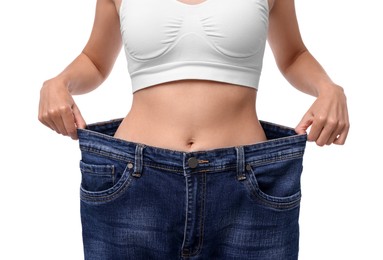 Diet and weight loss concept. Woman in big jeans showing her slim body on white background, closeup