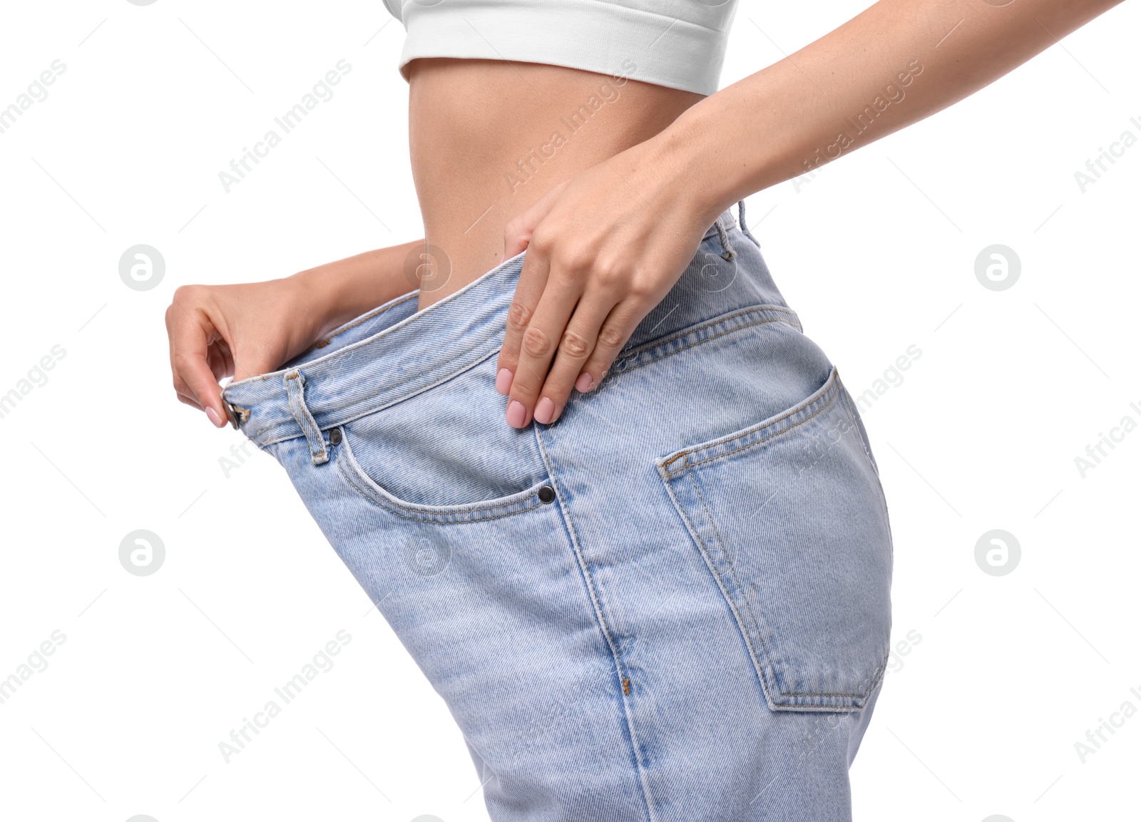 Photo of Diet and weight loss concept. Woman in big jeans showing her slim body on white background, closeup