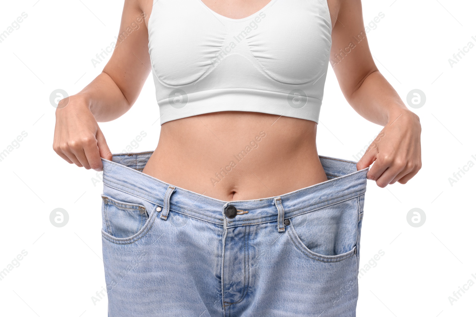 Photo of Diet and weight loss concept. Woman in big jeans showing her slim body on white background, closeup