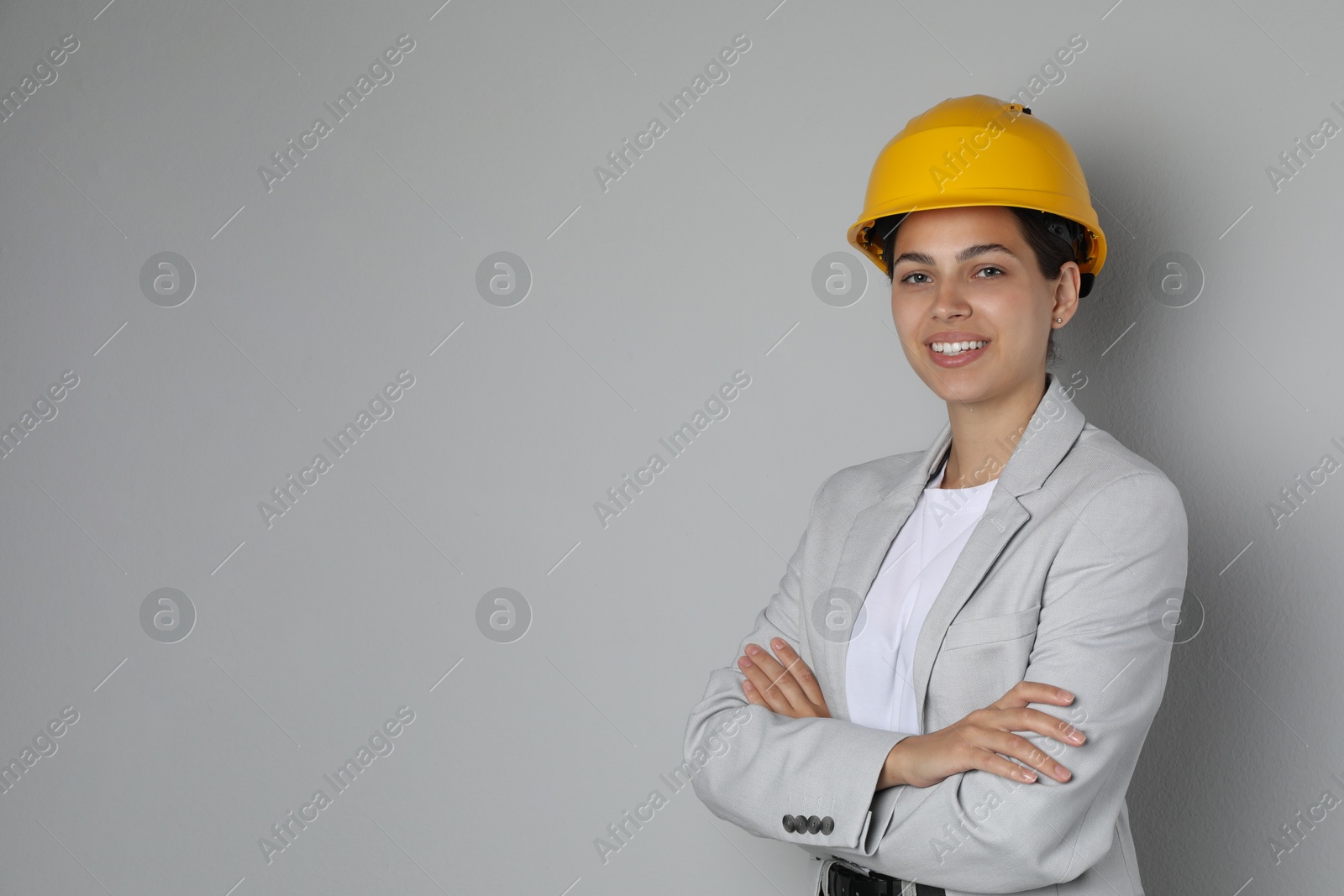 Photo of Engineer in hard hat on grey background, space for text