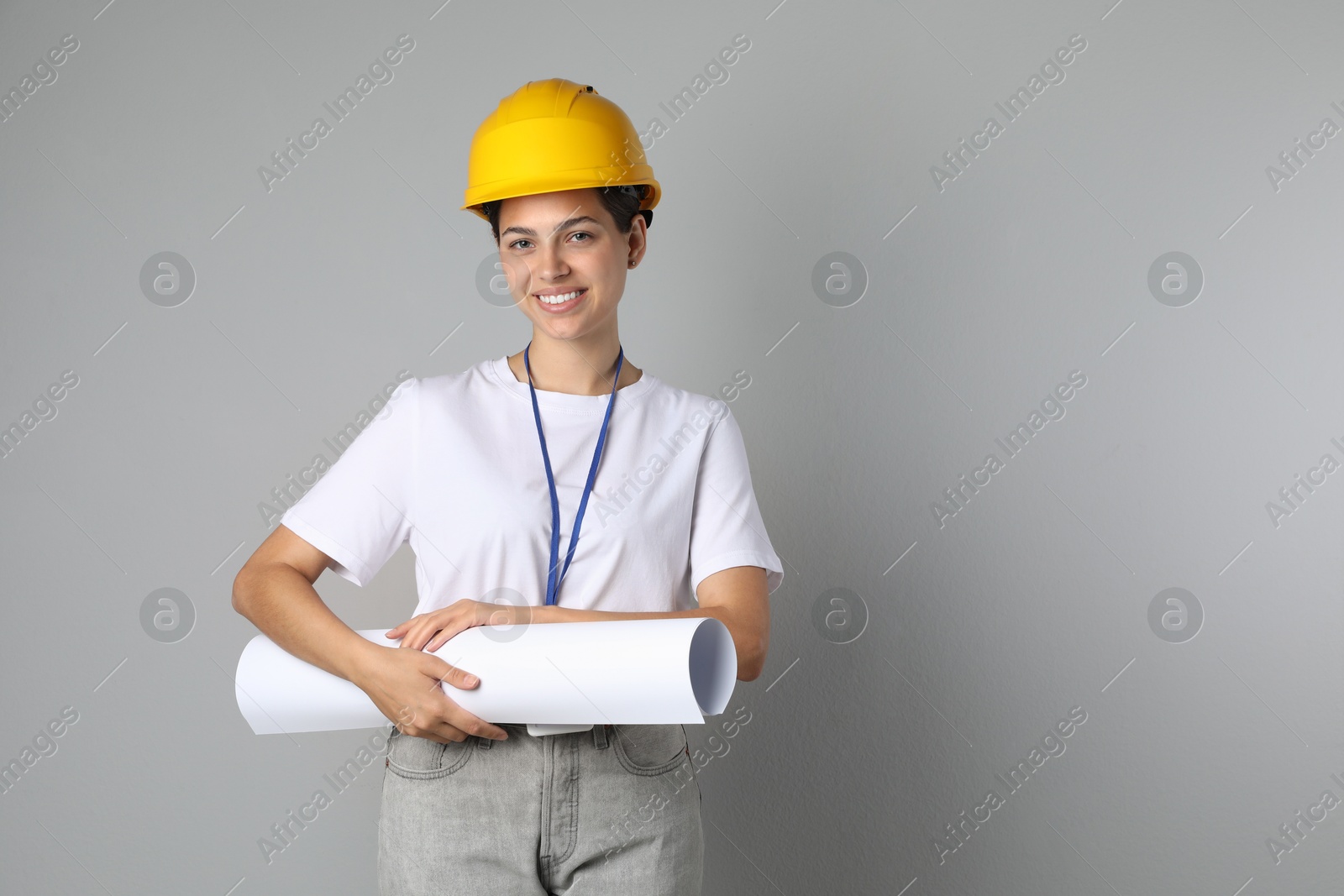 Photo of Engineer in hard hat with draft on grey background, space for text