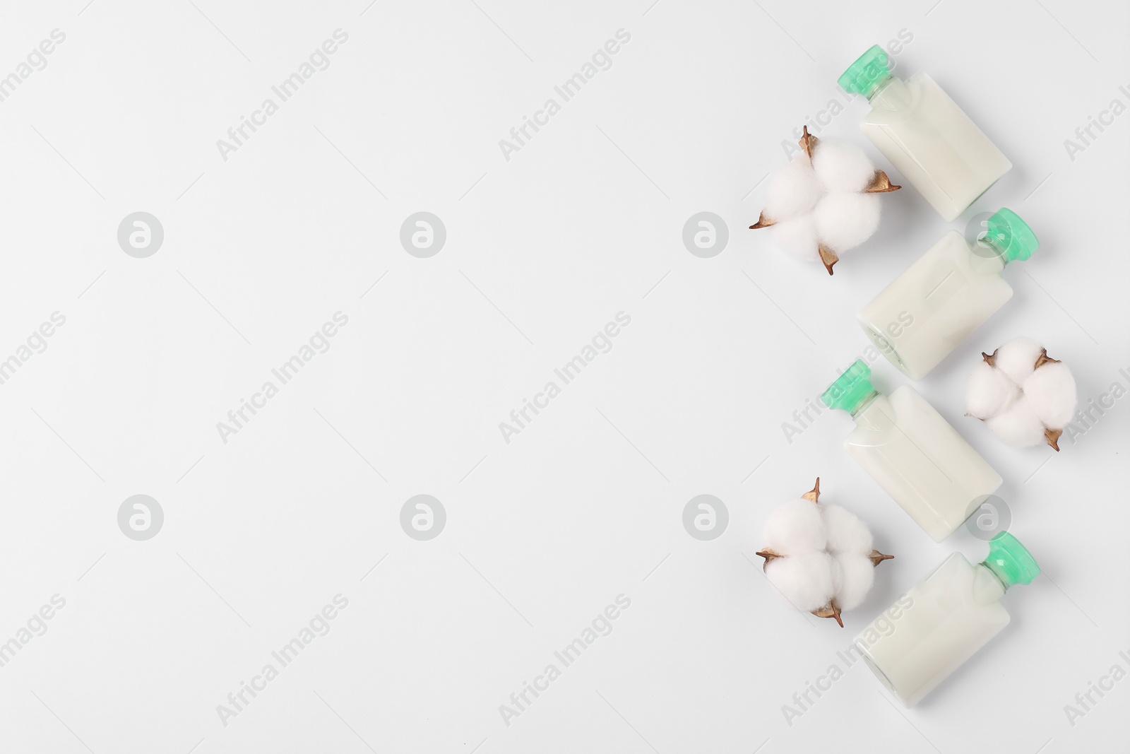 Photo of Cosmetic products and cotton flowers on white background, flat lay. Space for text