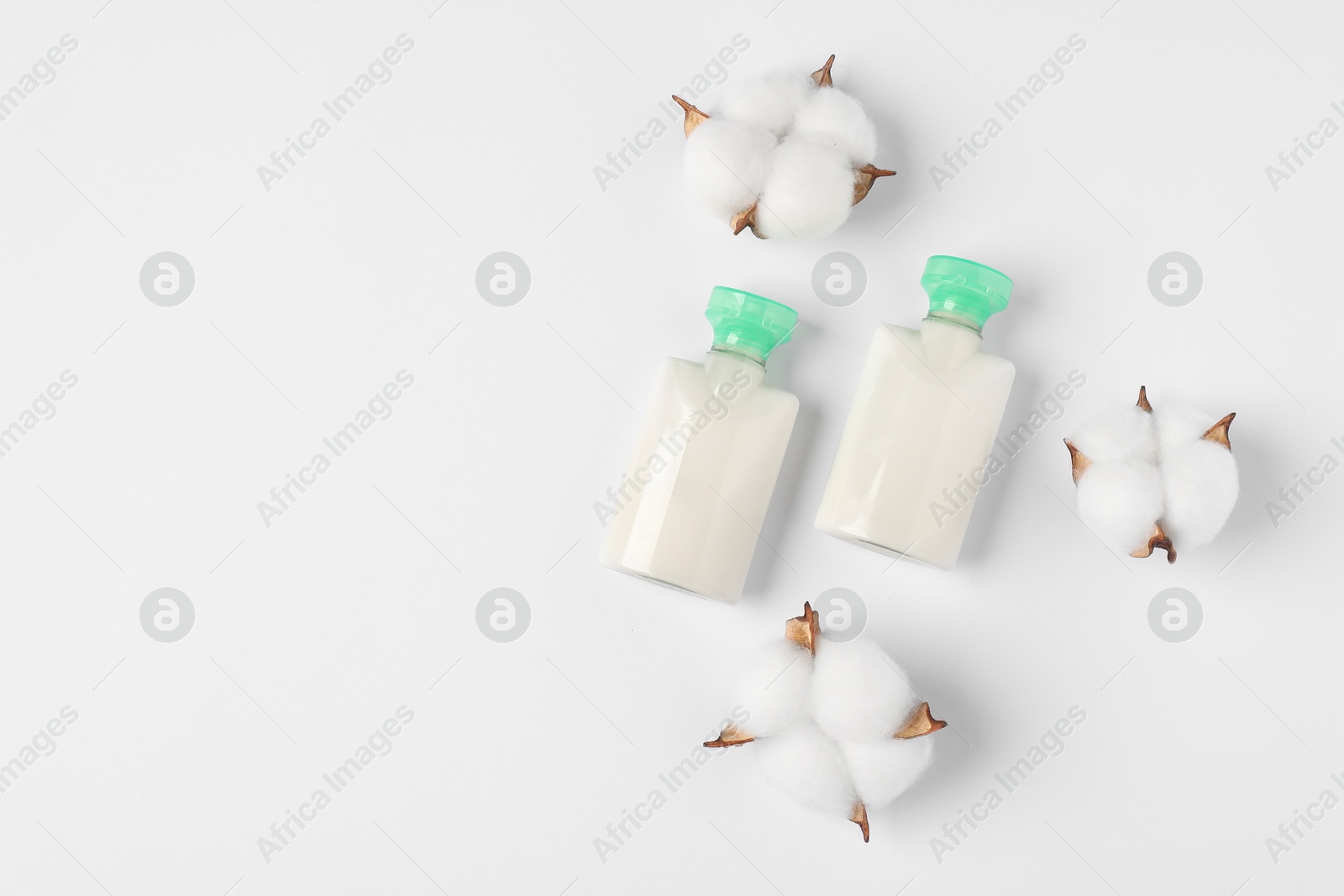 Photo of Cosmetic products and cotton flowers on white background, flat lay. Space for text