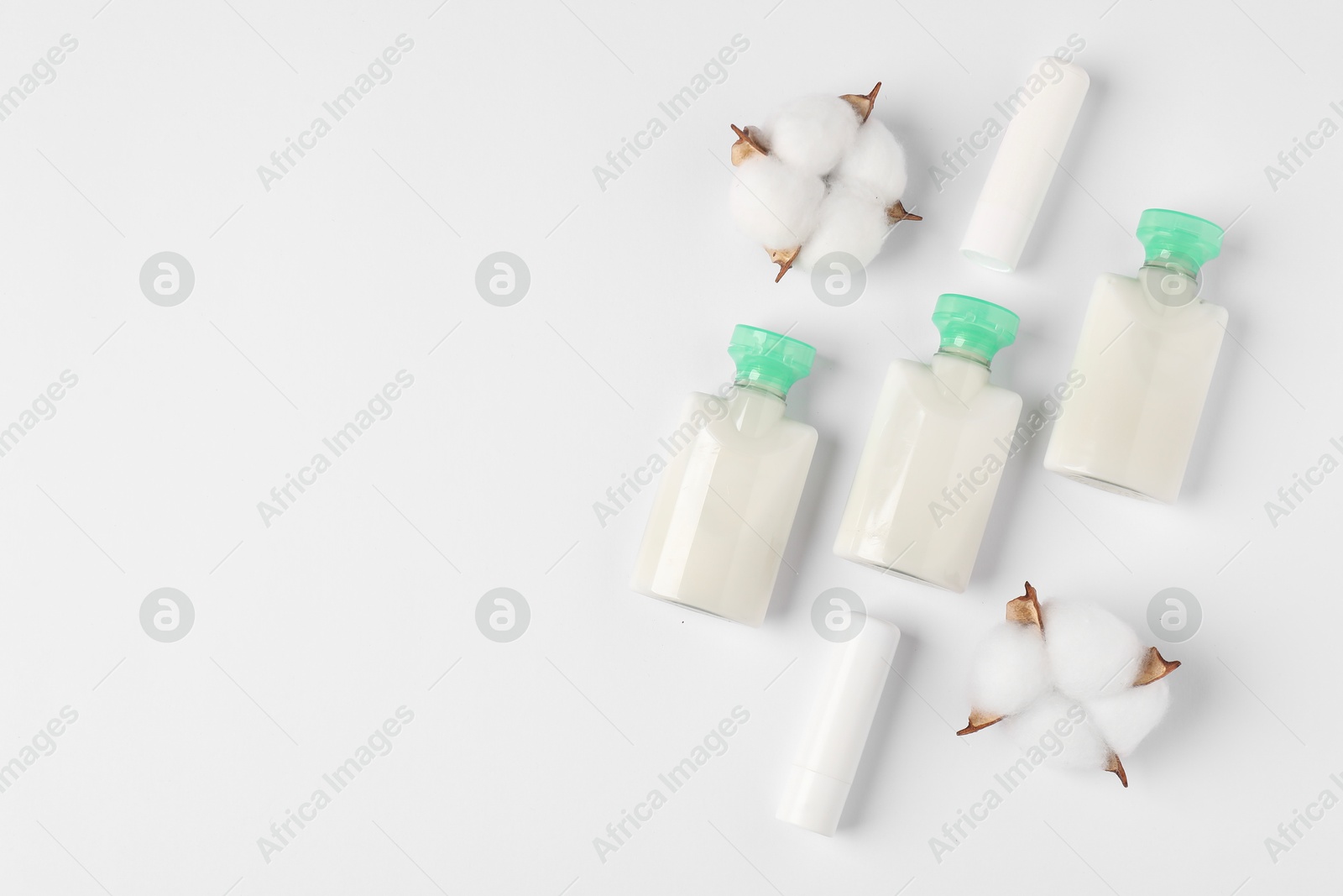 Photo of Different cosmetic products and cotton flowers on white background, flat lay. Space for text