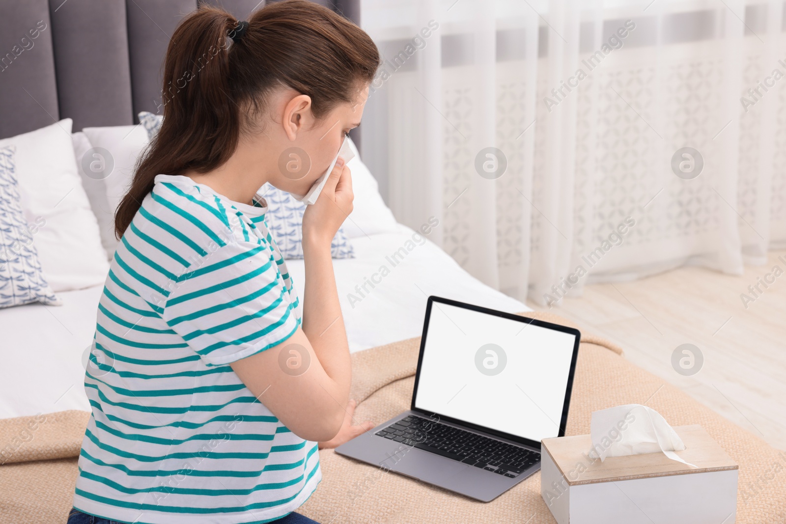 Photo of Sick woman having online consultation with doctor via laptop at home