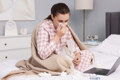 Photo of Sick woman having online consultation with doctor via laptop at home