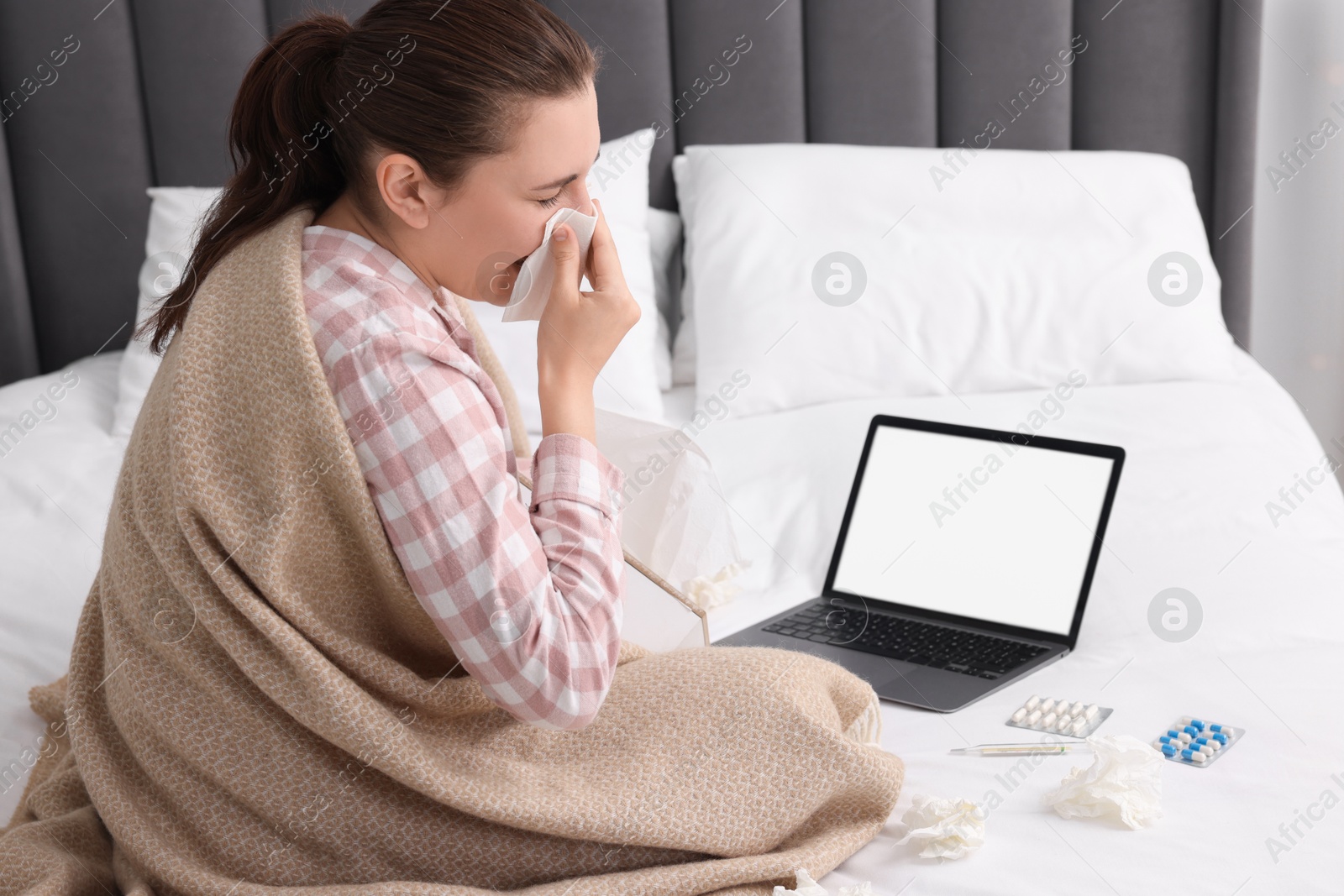 Photo of Sick woman having online consultation with doctor via laptop at home