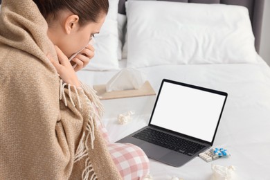 Sick woman having online consultation with doctor via laptop at home