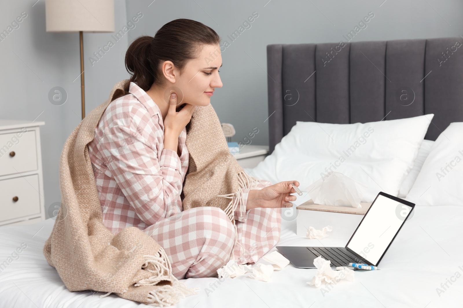 Photo of Sick woman having online consultation with doctor via laptop at home