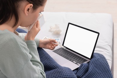 Photo of Sick woman with thermometer having online consultation with doctor via laptop at home
