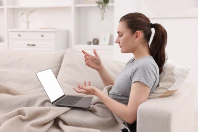 Photo of Sick woman having online consultation with doctor via laptop at home