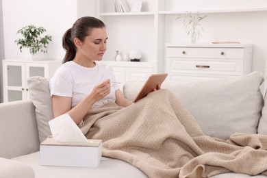 Sick woman having online consultation with doctor via tablet at home