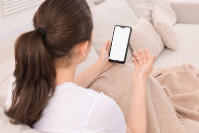 Sick woman having online consultation with doctor via smartphone at home