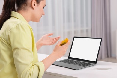 Photo of Sick woman having online consultation with doctor via laptop at white table indoors