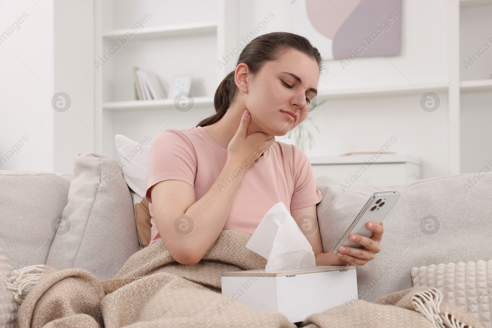 Photo of Sick woman having online consultation with doctor via smartphone at home