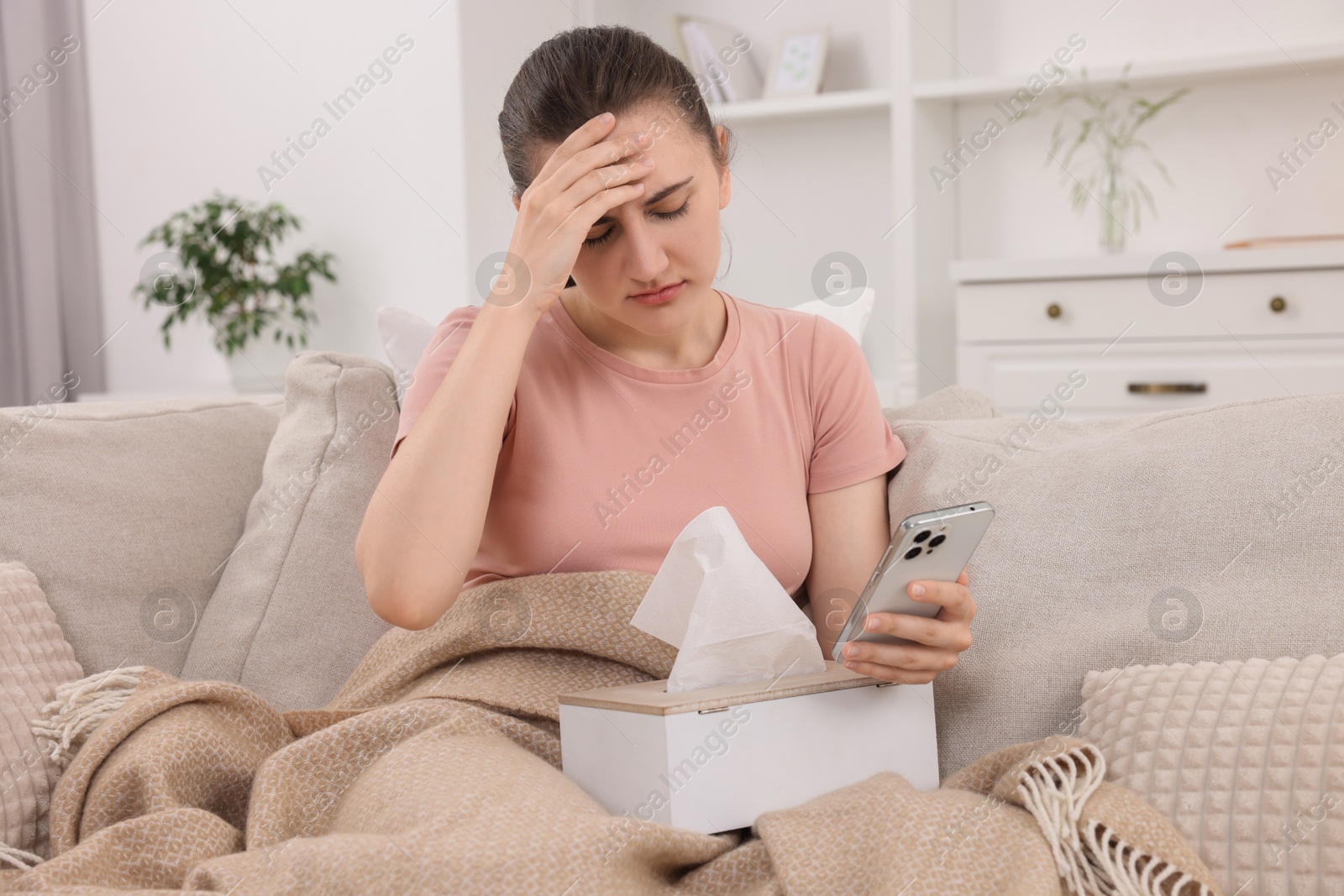 Photo of Sick woman having online consultation with doctor via smartphone at home