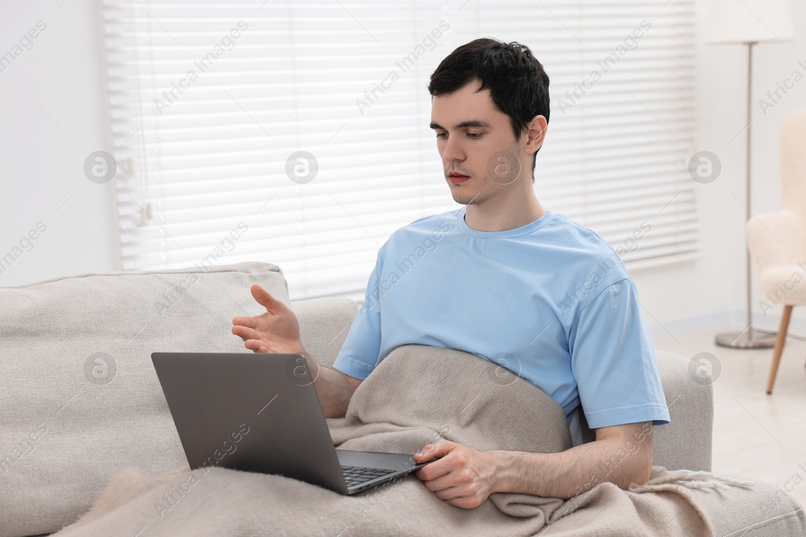 Photo of Sick man having online consultation with doctor via laptop at home