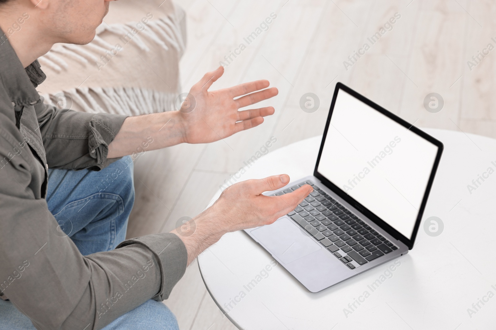 Photo of Sick man having online consultation with doctor via laptop at white table indoors, closeup