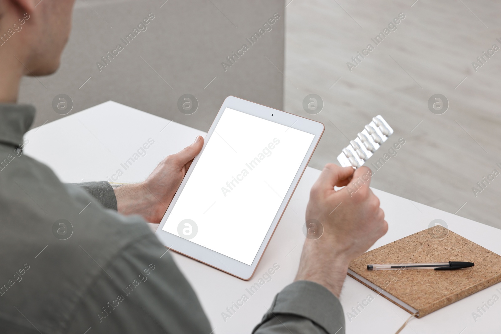 Photo of Sick man with pills having online consultation with doctor via tablet at home, closeup