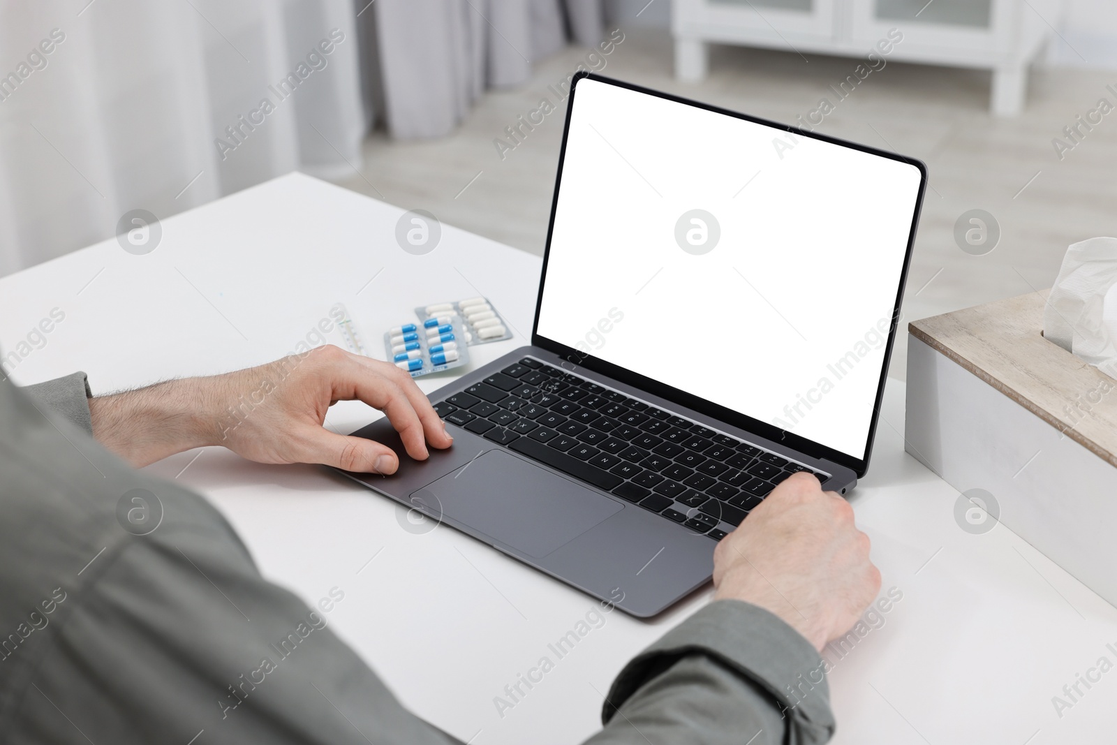 Photo of Sick man having online consultation with doctor via laptop at white table indoors, closeup