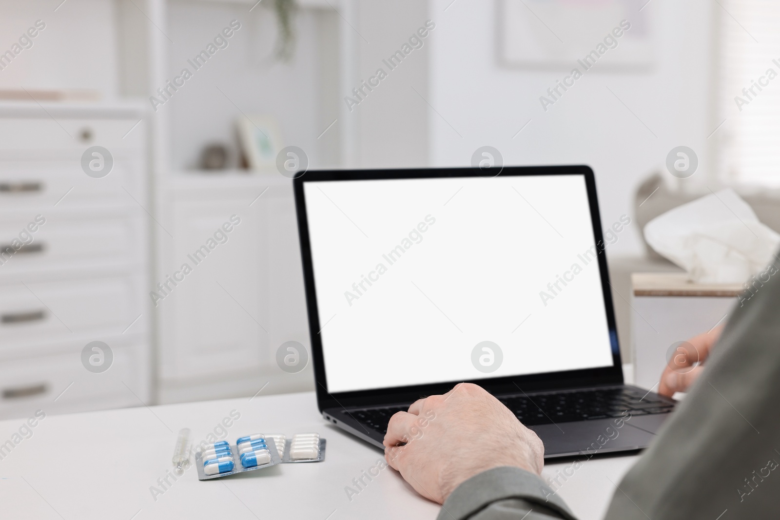 Photo of Sick man having online consultation with doctor via laptop at white table indoors, closeup