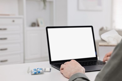 Photo of Sick man having online consultation with doctor via laptop at white table indoors, closeup