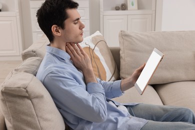 Photo of Sick man having online consultation with doctor via tablet at home