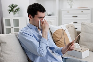 Sick man having online consultation with doctor via tablet at home