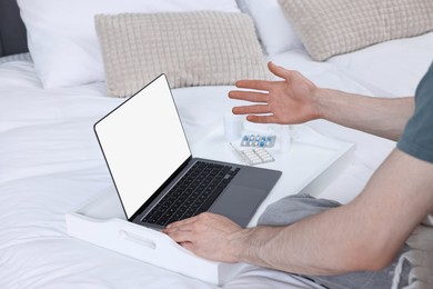 Sick man having online consultation with doctor via laptop at home, closeup