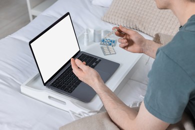 Photo of Sick man with thermometer having online consultation with doctor via laptop at home, closeup