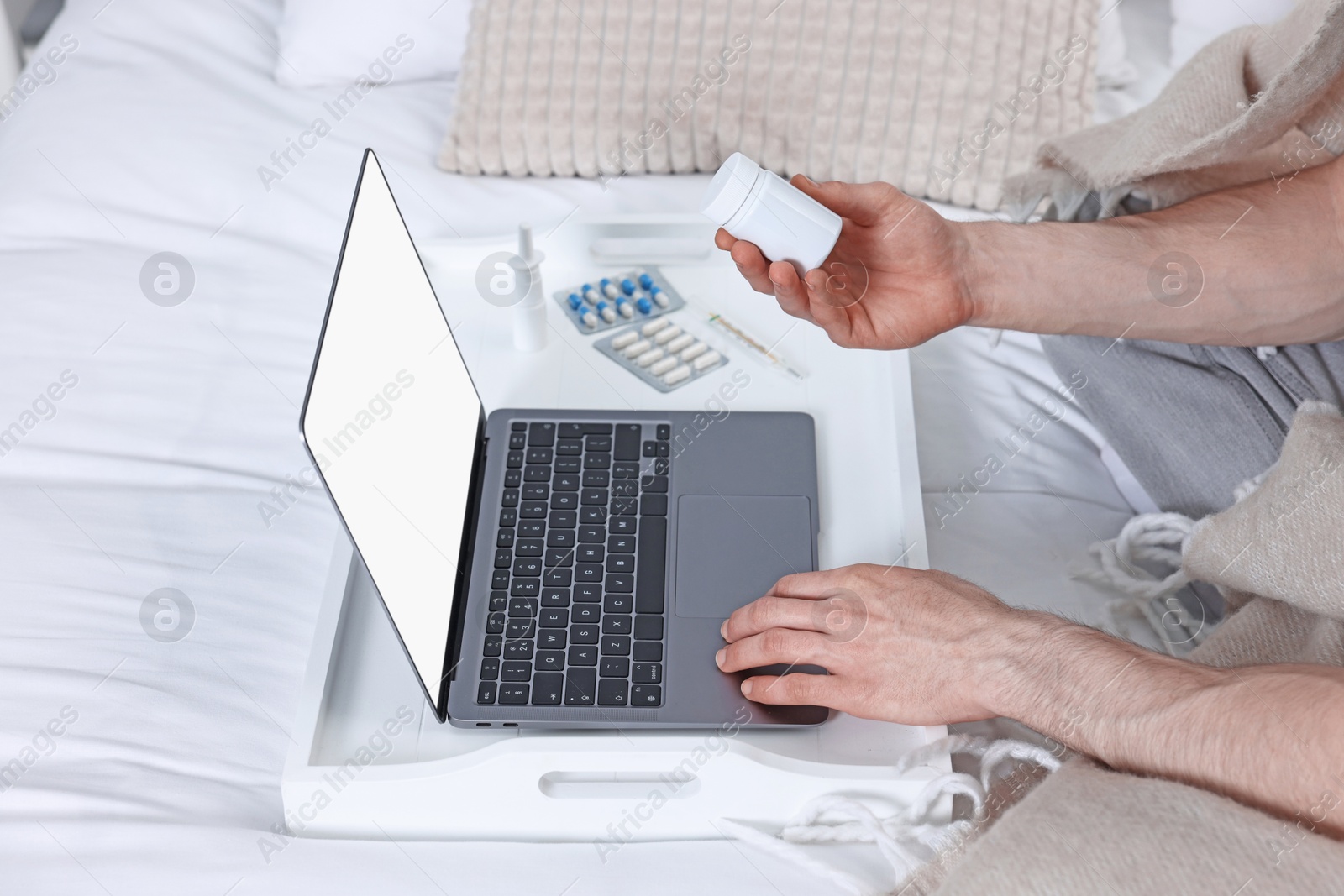 Photo of Sick man with pills having online consultation with doctor via laptop at home, closeup