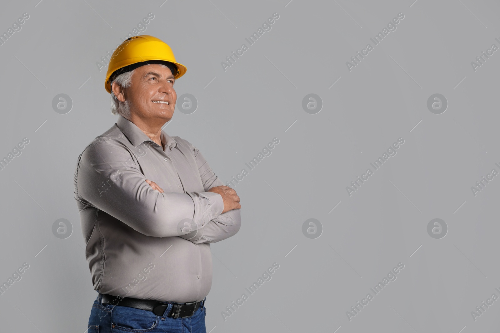 Photo of Engineer in hard hat on grey background, space for text