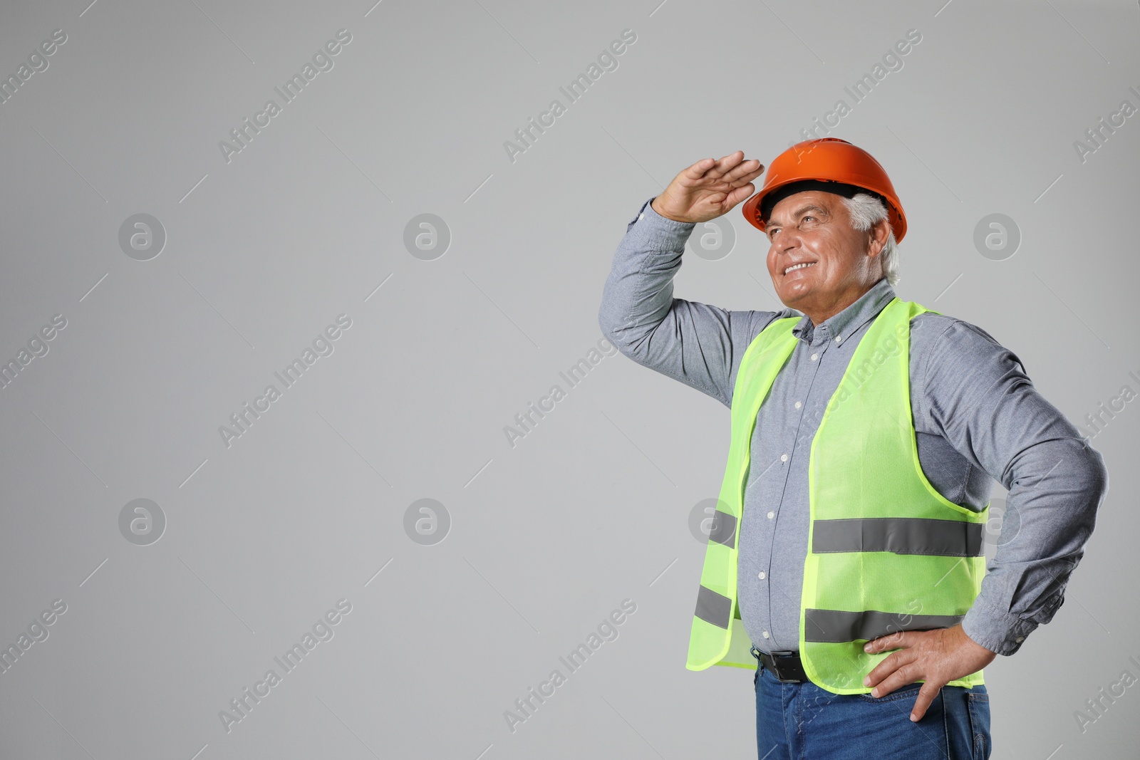 Photo of Engineer in hard hat on grey background, space for text