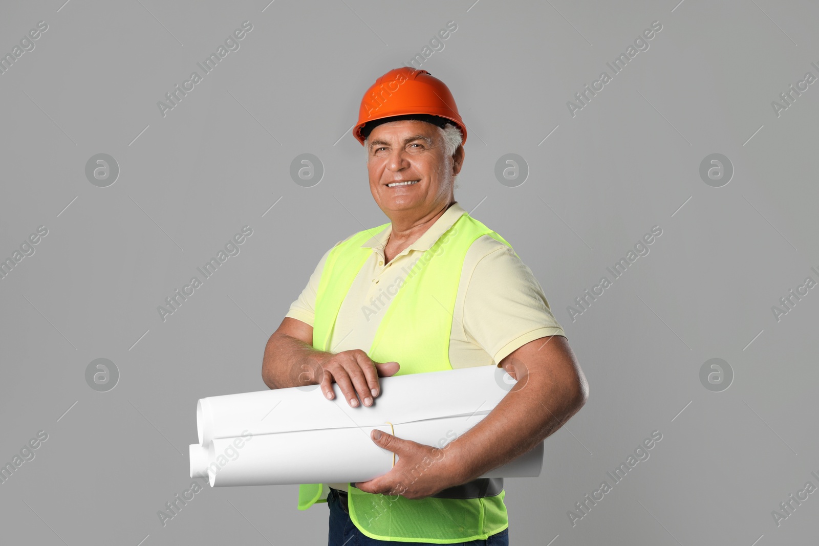 Photo of Engineer in hard hat with drafts on grey background