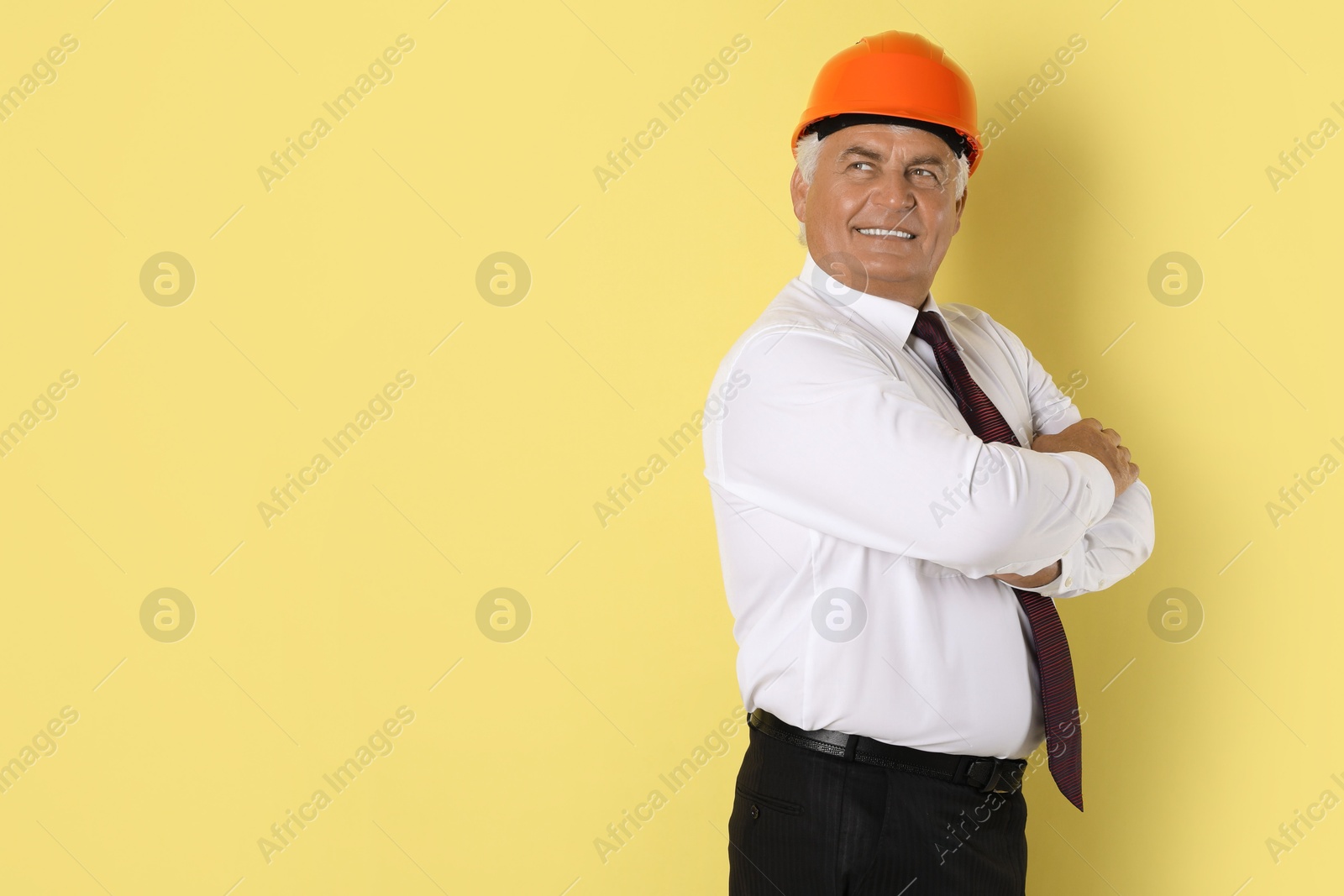 Photo of Engineer in hard hat on yellow background, space for text