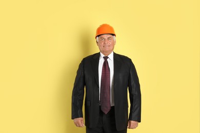 Engineer in hard hat on yellow background