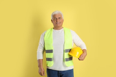 Photo of Engineer with hard hat on yellow background