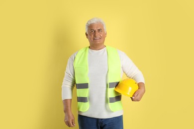 Engineer with hard hat on yellow background