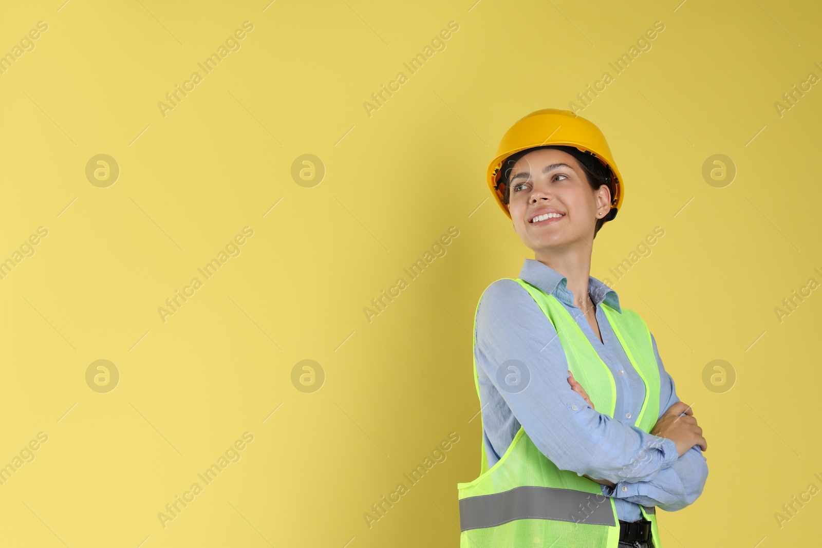 Photo of Engineer in hard hat on yellow background, space for text