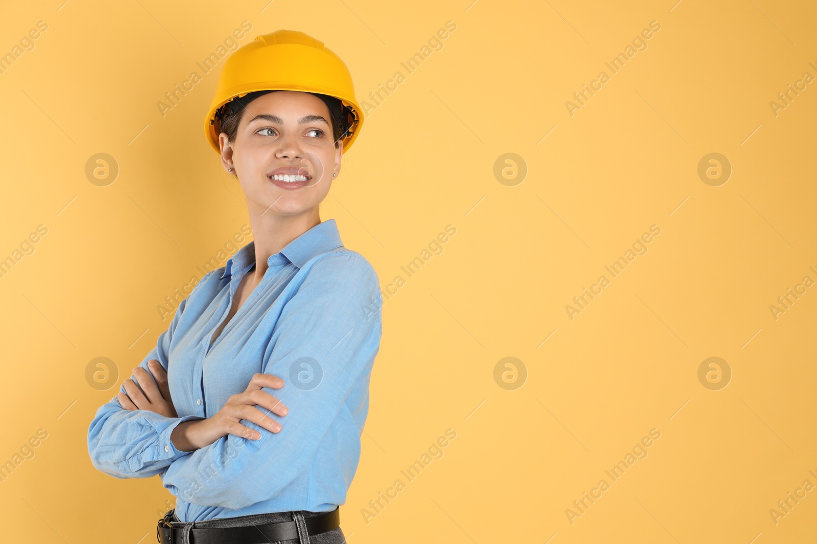 Photo of Engineer in hard hat on yellow background, space for text