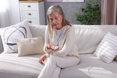 Photo of Senior woman with emergency call button at home