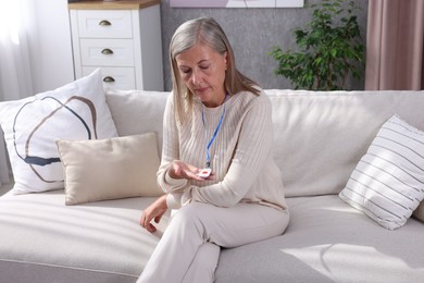 Senior woman with emergency call button at home