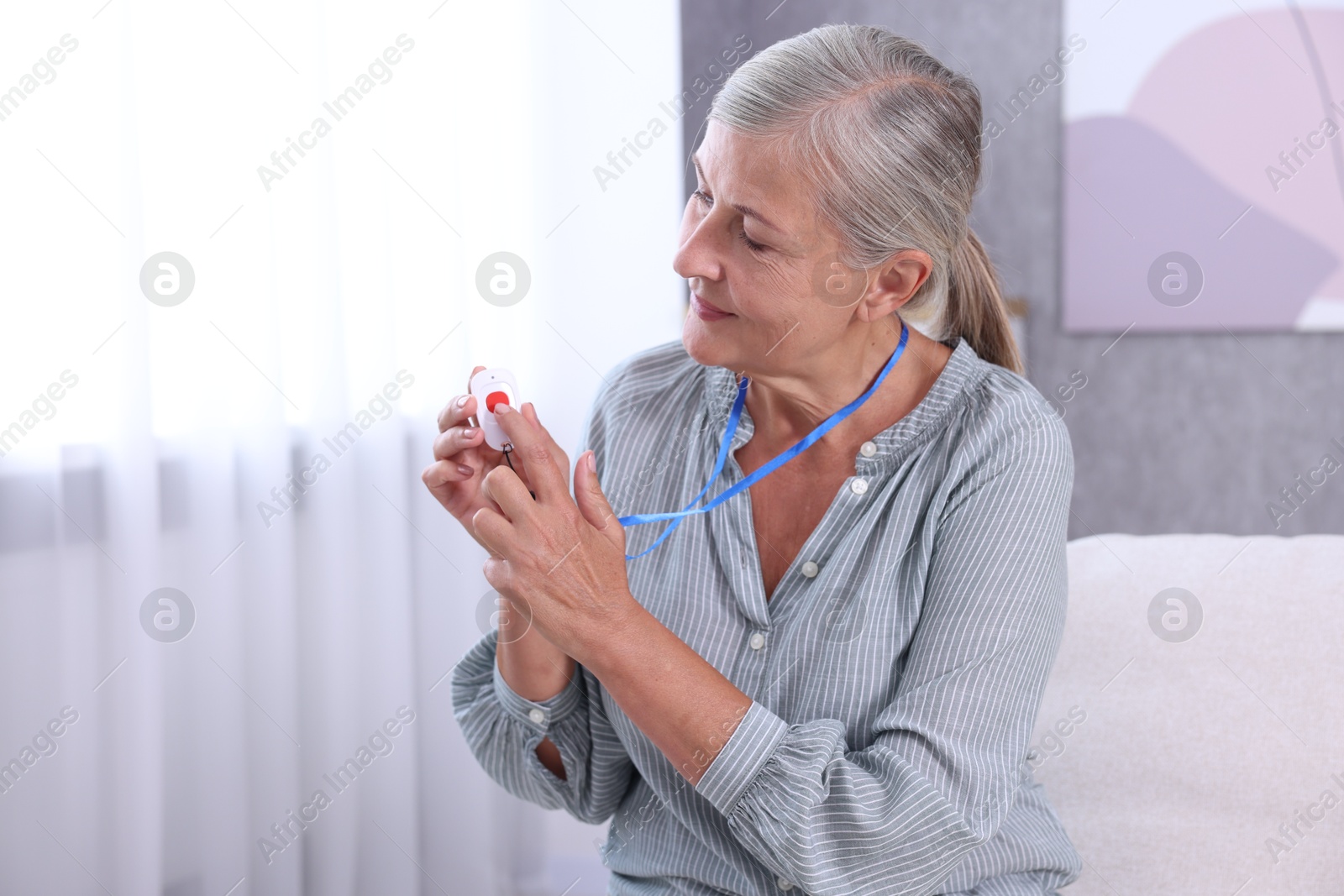 Photo of Senior woman pressing emergency call button at home